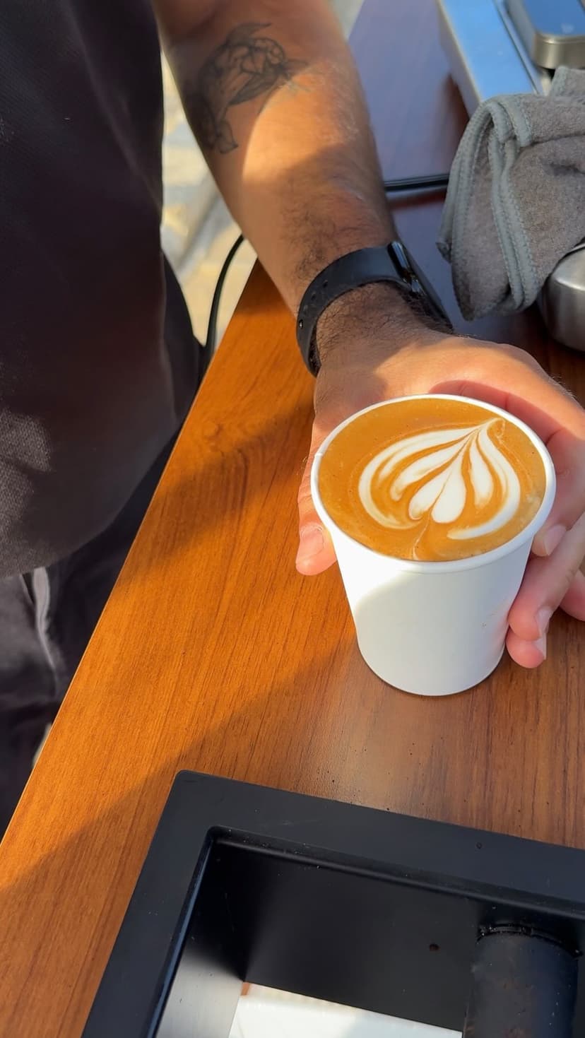 Barista de Caféalo sirviendo un latte con arte